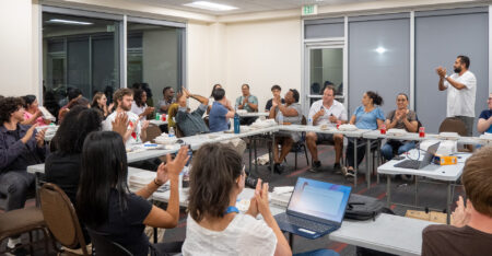 Photo of a group of people in a meeting room clapping