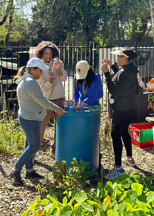 Photo of women around a rain barrel