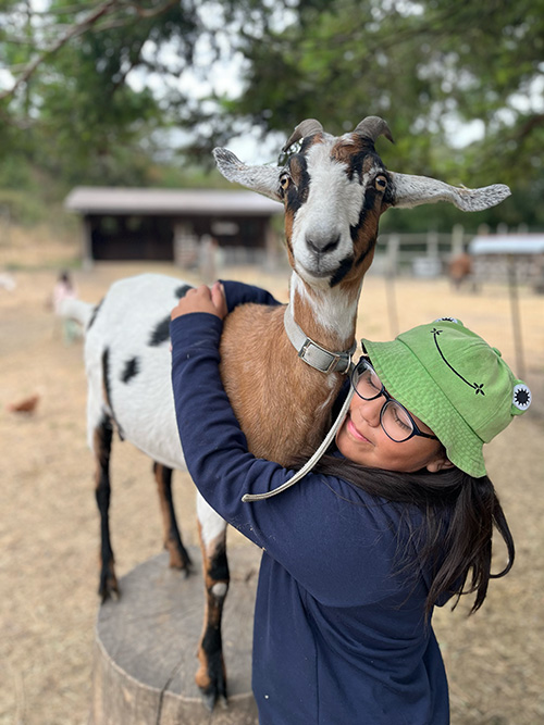 Photo of girl hugging a goat